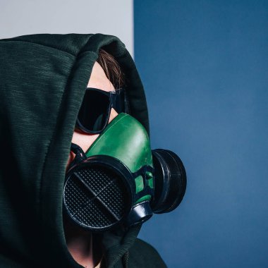 Gaz maskeli ve kapüşonlu koruyucu gözlüklü bir adamın yakın plan portresi.. 