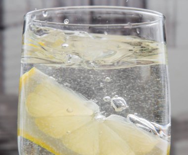 Bir dilim limon suya atılmış ve sıçrayan.