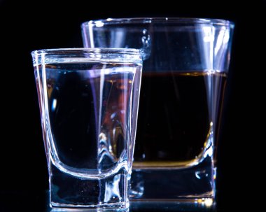 Bir bardak votka ve bir bardak brendi, viski veya bourbon beyaz veya renkli arka plan üzerinde