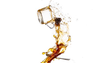 Siyah çaylı şeffaf kupa ters dönmüş ve sıçrama ve spreyle yere düşmüş.