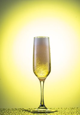 Düşen bir şampanya bardağının içine sarı bir arkaplan serpiştir.