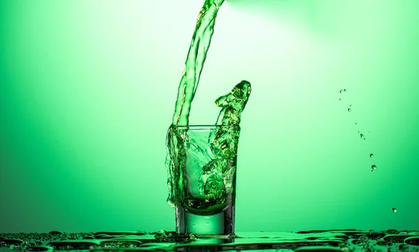 Splash Falling Glass Absinthe Vodka Green Gradient Background — стоковое фото