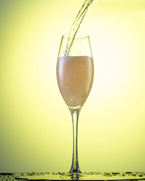 Düşen Bir Şampanya Bardağının Içine Sarı Bir Arkaplan Serpiştir — Stok fotoğraf