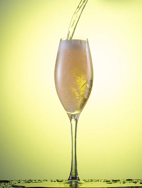 Düşen Bir Şampanya Bardağının Içine Sarı Bir Arkaplan Serpiştir — Stok fotoğraf