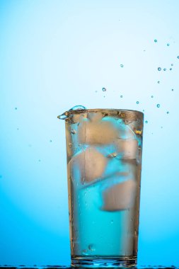 Sarı ya da yeşil karbonatlı limonata. Bardakta buz, akış ve sıçrama var.