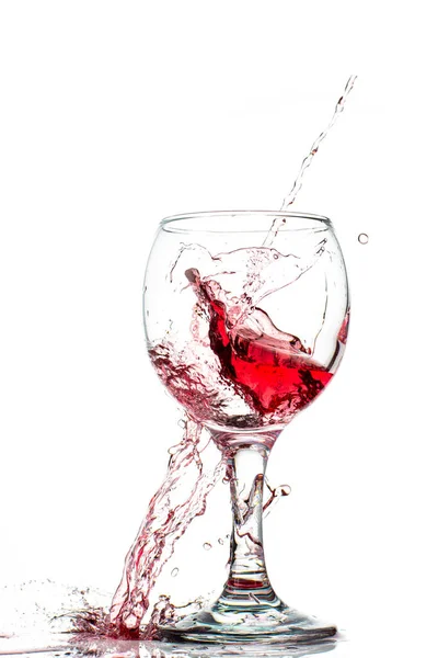 白い背景に丸みを帯びたガラスの中に赤ワインが落ちるスプラッシュ — ストック写真
