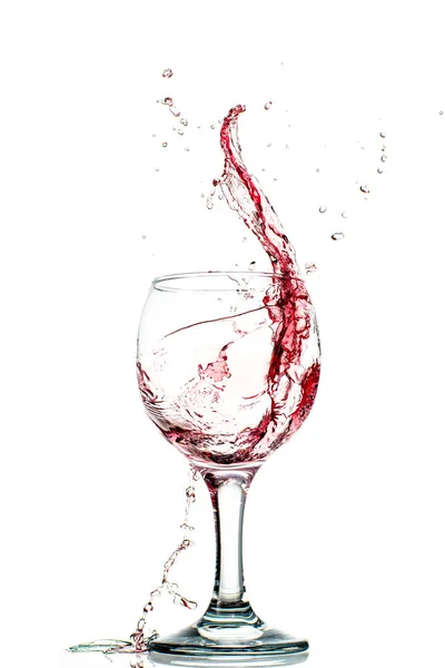 白い背景に丸みを帯びたガラスの中に赤ワインが落ちるスプラッシュ — ストック写真