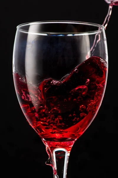 Spritzer Fallender Rotwein Einem Runden Glas Auf Schwarzem Hintergrund — Stockfoto