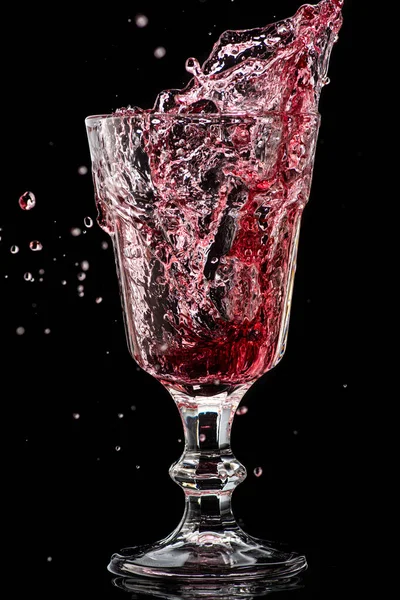 Stänk Fallande Rött Vin Ett Runt Glas Svart Bakgrund — Stockfoto