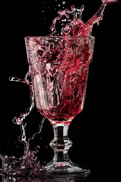 Stänk Fallande Rött Vin Ett Runt Glas Svart Bakgrund — Stockfoto