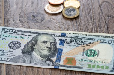 Avro paraları ve tahtadan arka planda 100 dolar.