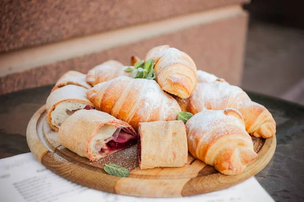 Fresh croissants with crispy crust with cherry and chocolate fil