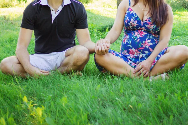 Heureux couple enceinte méditer sur l'herbe — Photo