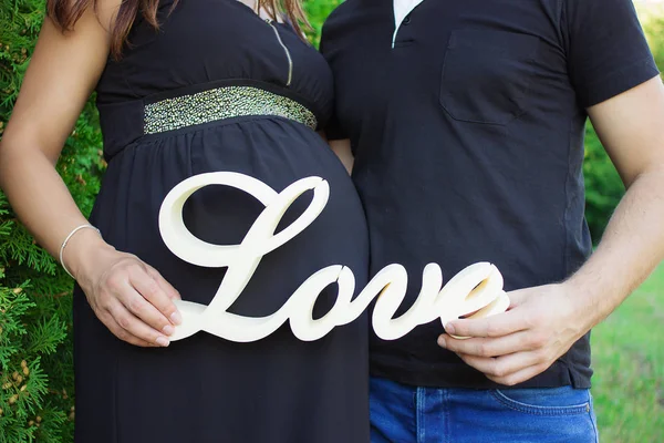 Casal grávida segurando a palavra amor — Fotografia de Stock