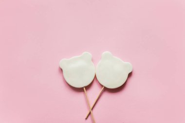Pembe bir arka plan üzerinde beyaz panda lolipop çapraz yalan