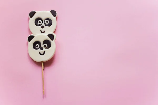 Улыбающиеся панда леденцы на розовом фоне — стоковое фото