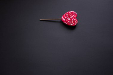 Bir kalp şeklinde bir çubuk üzerinde kırmızı şeker