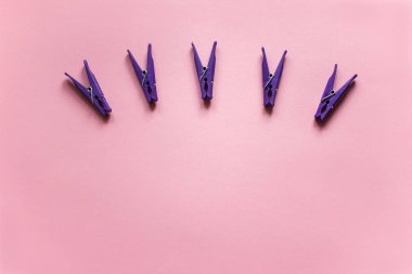 Grup mor clothespins yalan pembe bir arka plan üzerine