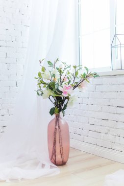 Vazo Çiçekleri ile hafif bir odada katta duruyor 
