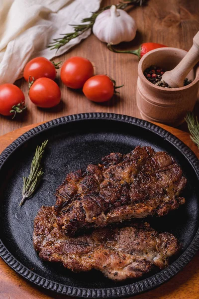 Gebratenes Steak Mit Gewürzen Einem Eisenteller Auf Einem Holztisch Tomaten — Stockfoto