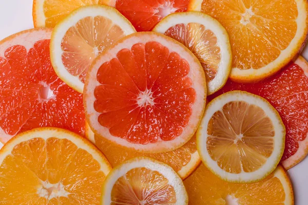 Orange grapefrukt och citron styckning i en platta på en trä bakgrund — Stockfoto
