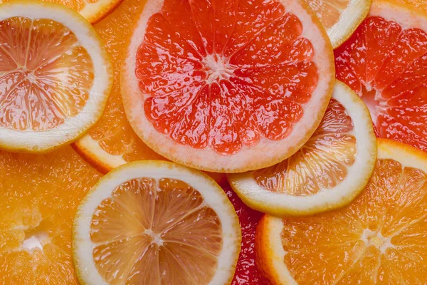 Orange grapefrukt och citron styckning i en platta på en trä bakgrund — Stockfoto