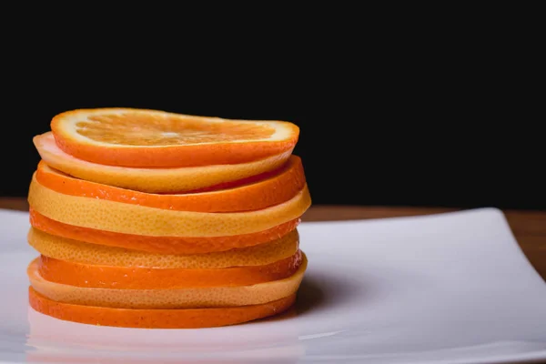 Orange grapefrukt och citron styckning i en platta på en trä bakgrund — Stockfoto