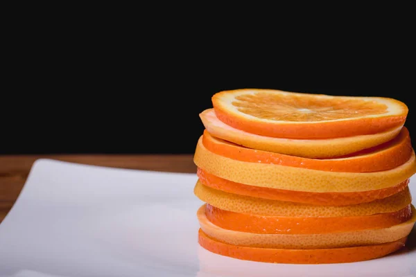 Orange grapefrukt och citron styckning i en platta på en trä bakgrund — Stockfoto