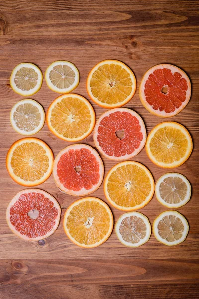 Citrusfrukter som halveras - apelsiner, mandariner, citroner och grapefrukt på en trä bakgrund — Stockfoto