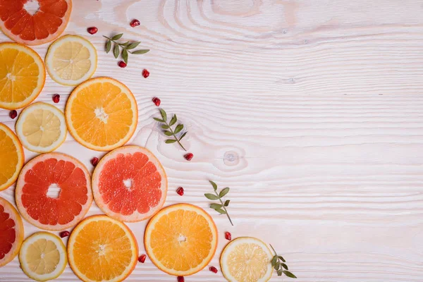 Citrus fruit cut in half - oranges, lemons, tangerines, grapefruit on a wooden background