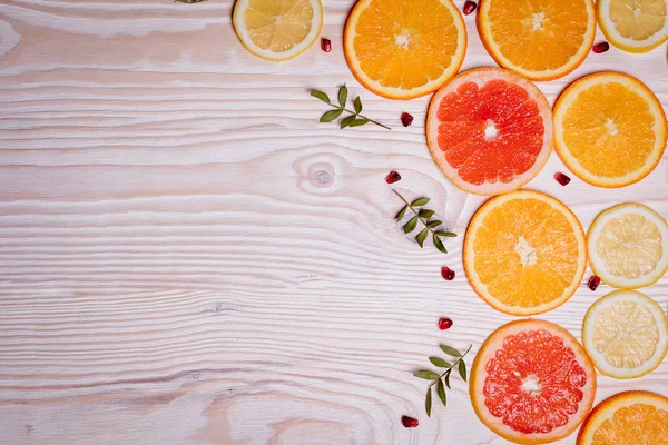 Citrus fruit cut in half - oranges, lemons, tangerines, grapefruit on a wooden background