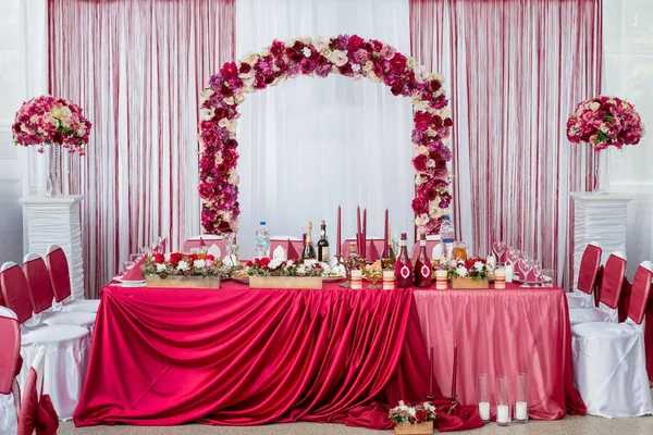 Весільний стіл для молодят. прикрашені свіжими квітами і червоною скатертиною — стокове фото