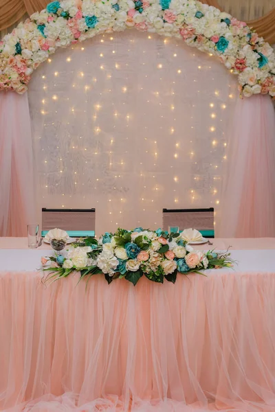 Festligt bord för bruden och brudgummen dekorerad med tyg och blommor — Stockfoto