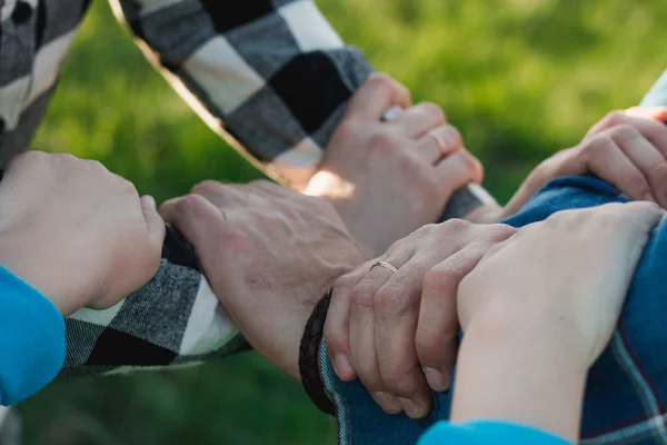 Hands and hearts together. Close-up of loving family holding hand