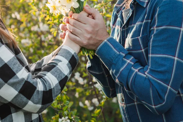 Fiú és lány azt mutatják, szeretetet és tiszta érzéseket, egymást. Nő, és mosolyogva, átölelve ember tartja a csokor virág. — Stock Fotó