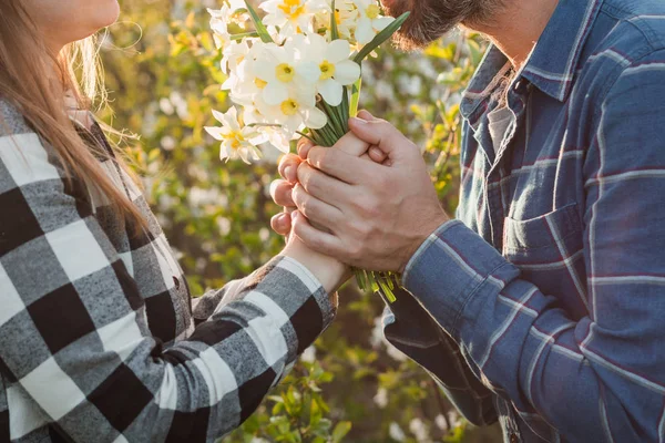 Muestran amor y sentimientos puros el uno por el otro. Mujer sonriendo y abrazando Hombre sosteniendo ramo de flores . — Foto de Stock