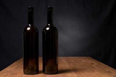 Ahşap arka plan karşı masada şarap şişeleri