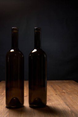 Ahşap arka plan karşı masada şarap şişeleri