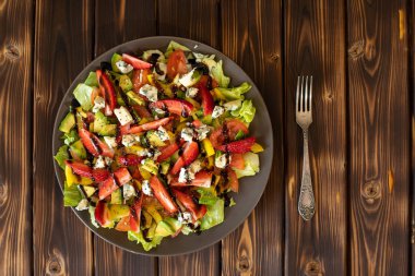 Bir tabak küflü peynir salatası. Tabak ahşap bir masanın üzerinde duruyor. Yakın plan..