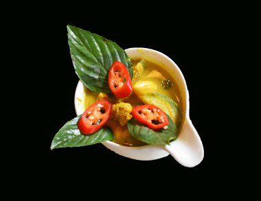 Yeşil köri tavuk biber ve siyah arka plan üzerine fesleğen ile tepesi.