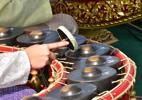 Tay müzisyen gong oynuyor (Tay vurmalı çalgılar, İşte adım birçok, bir daire içinde düzenlenmiş).