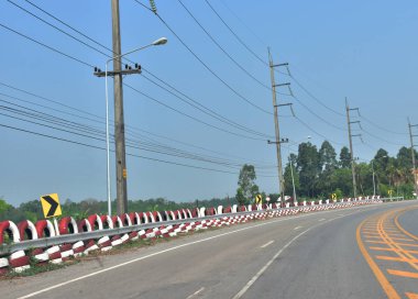Orada eski beyaz ve kırmızı, yan lastikler kaza sembol uyarı. Bu da lightstreet direkleri ve ağaca yan da vardır. Arka plan gökyüzü nedir.