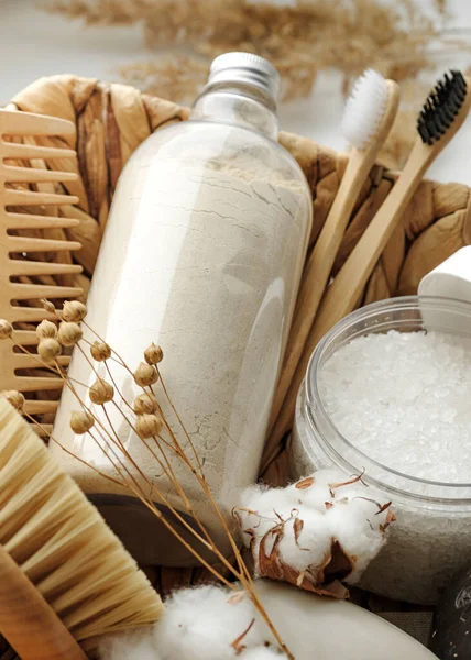 Spa and wellness cosmetic products:body scrub,beech toothbrushes,sea bath salt,soap, wooden hair comb in a wicker basket