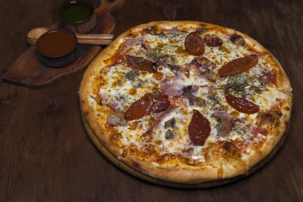 Pizza met ham, kaas, kalfsvlees en zongedroogde tomaten — Stockfoto