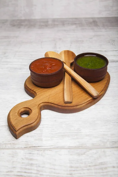 Kırmızı ve yeşil sos ile tahta kaşıklar