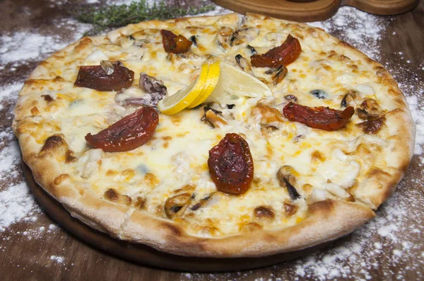 Pizza met zeevruchten, gedroogde tomaten en kaas — Stockfoto