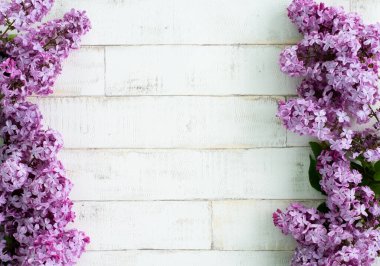 Açık arkaplanda bir ağacı taklit eden parlak, mor bir leylak. Ahşap zemin, dallar ve arka planda duran leylak çiçekleri. Dekor için fotofon