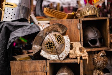 Bit pazarı sırası. Satılık antika eşyalar. Şövalye miğferi, hayvan kafatası, doldurulmuş kuş..