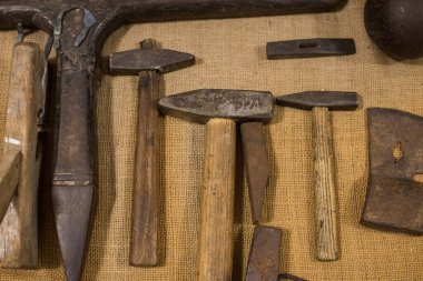 Eski paslı çekiç koleksiyonu ahşap bir yüzeyde. Eski araçlar