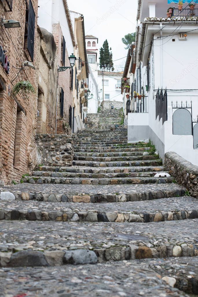 Spain, Granada. Architecture of old city. Wide granit stone steps leading up